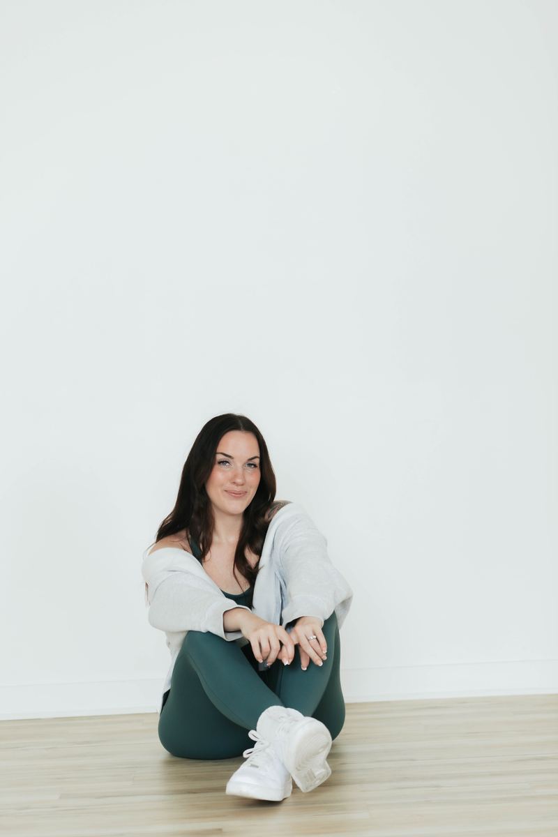 Coach Em sitting on the studio floor